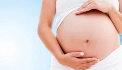 Mulher grávida com mãos sobre a barriga