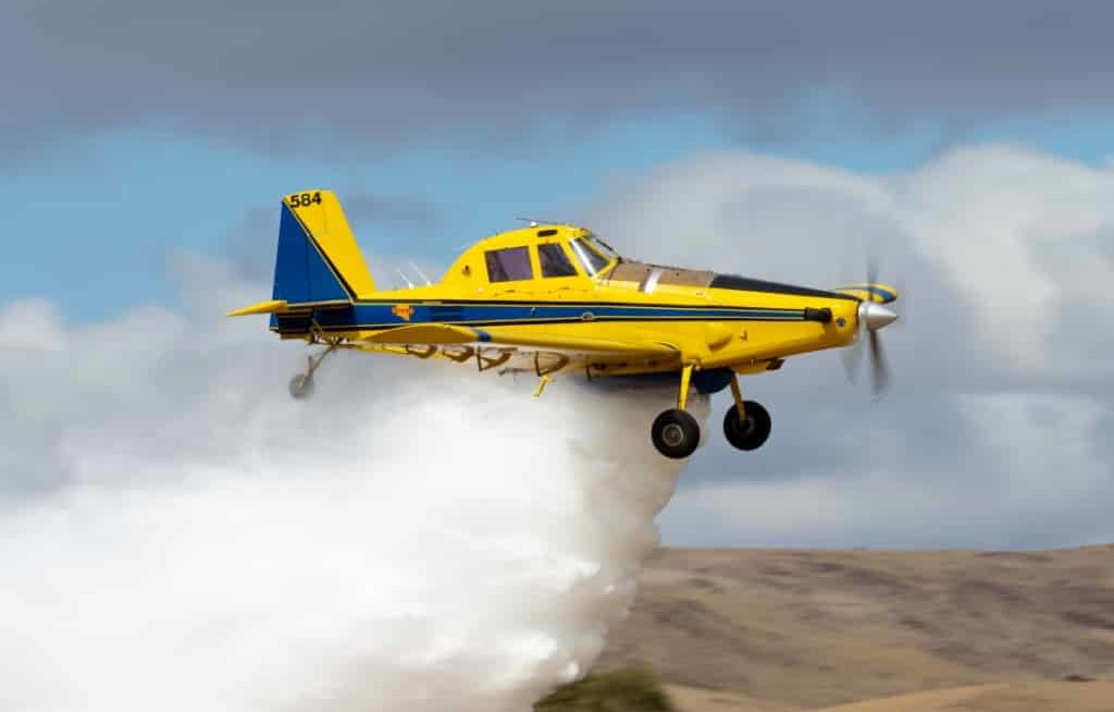 Avião agrícola amarelo pulverizando