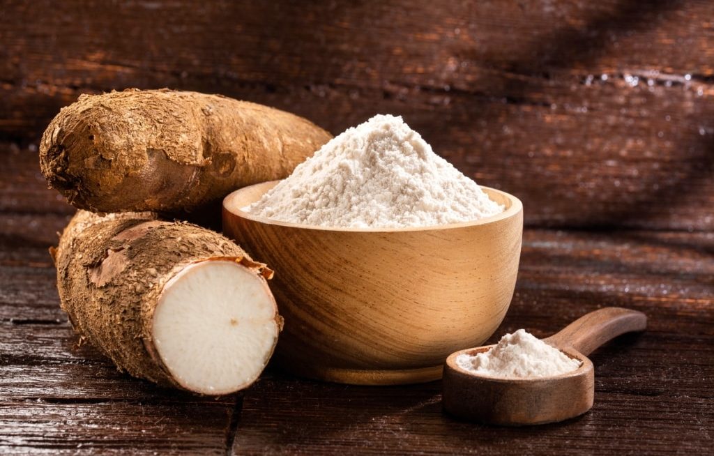 Mandioca e farinha em pote ao lado