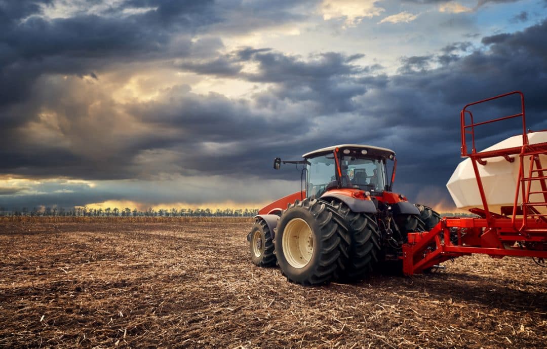 Trator com implemento agrícola no campo