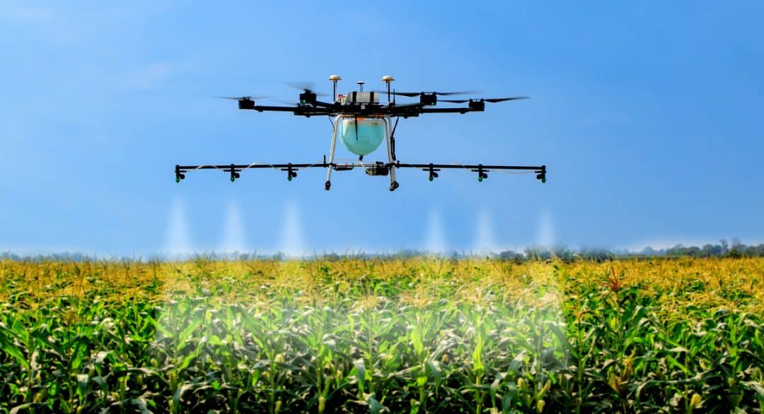 Drone aplicando defensivo agrícola na lavoura.