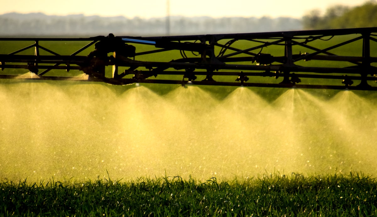 Máquina pulverizando lavoura com fertilizante foliar