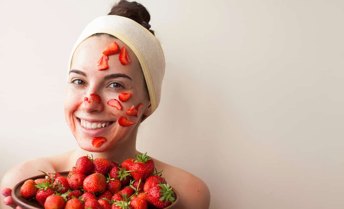 Moça com pedaços de fruta no rosto