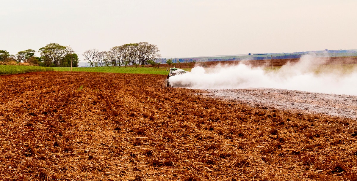 Trator realiza calagem em área preparada para plantio