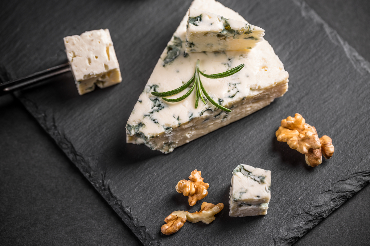 Gorgonzola em cubos e pedaço maior com sua cor tradicional