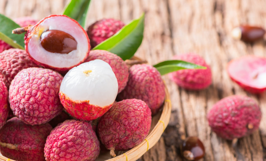 Frutos de lichia, inteiros e descascados, mostrando sua polpa e semente