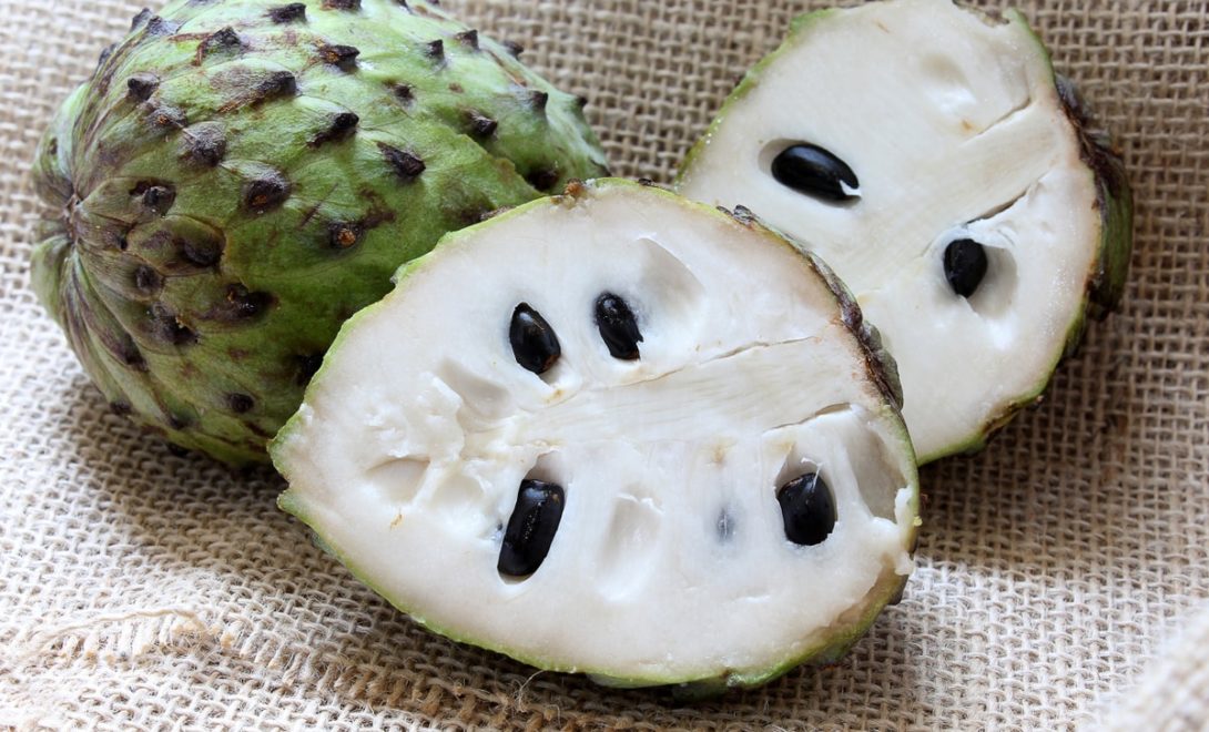 Atemoia inteira e atemoia cortada ao meio sobre tecido