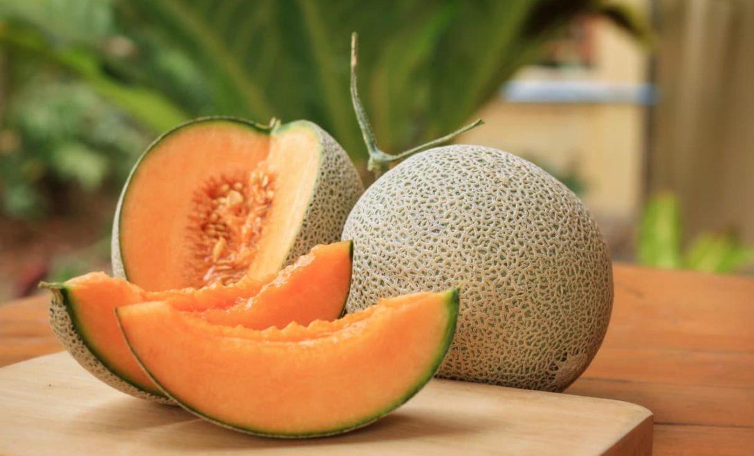 Fatias de melão do tipo cantaloupe americano, sobre tábua de madeira