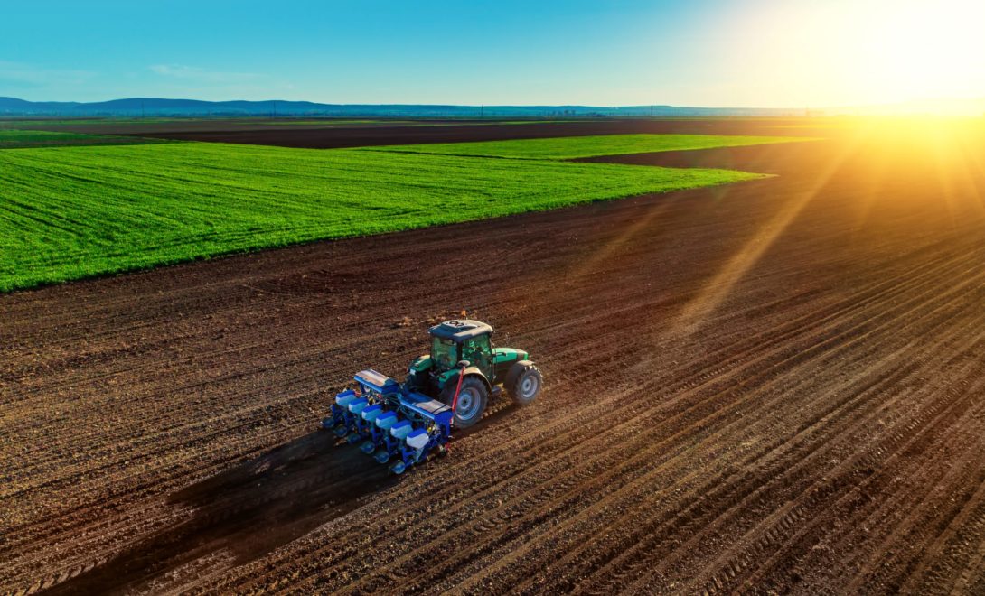 Trator com semeadora em campo