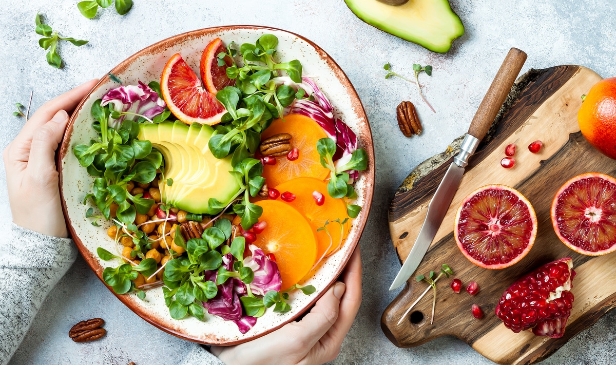 Prato com frutas fatiadas, ervas e sementes de romã