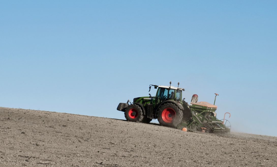 Trator com implemento em terreno inclinado