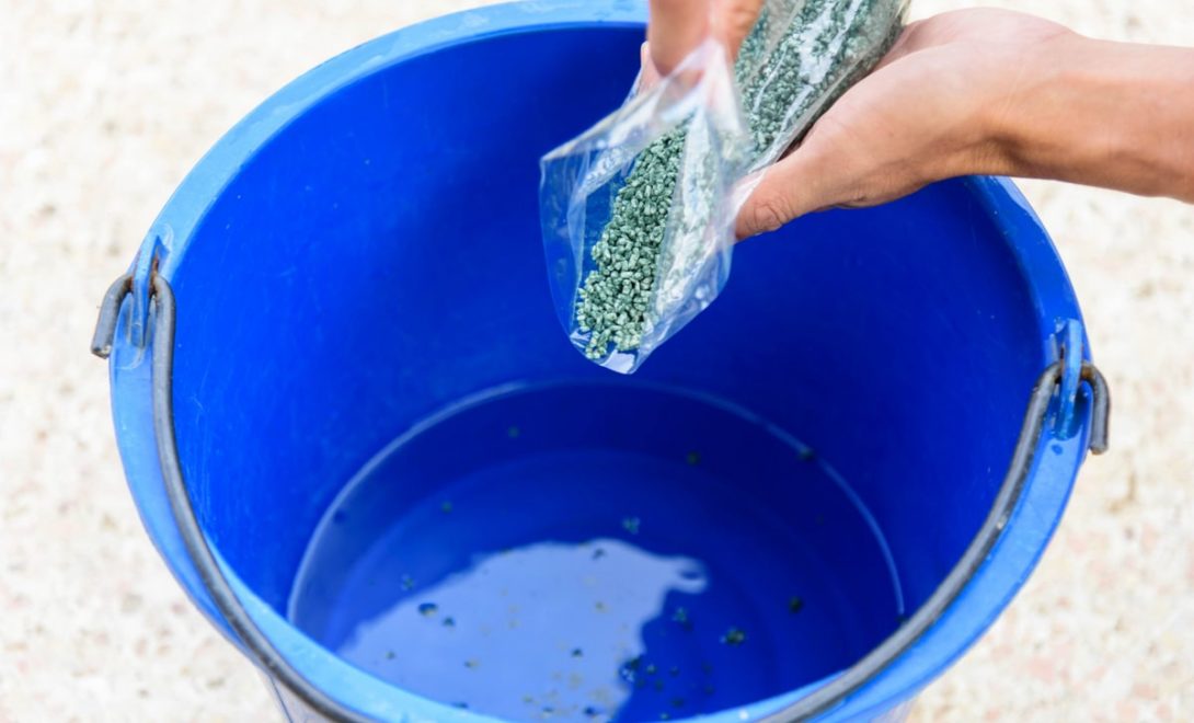 Biodefensivo à base de Trichoderma sendo diluído em água em um balde azul