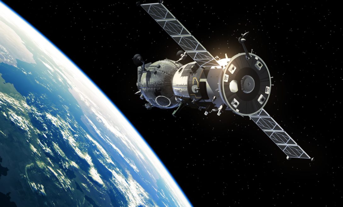 Satélite, à direita, orbitando o planeta terra, à esquerda.