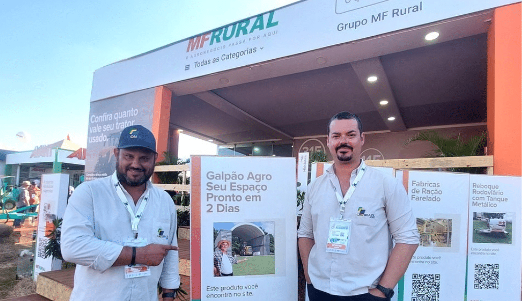 Davi Calefi e parceiro ao lado de totem em exposição no estande do MF Rural na Agrishow 2023
