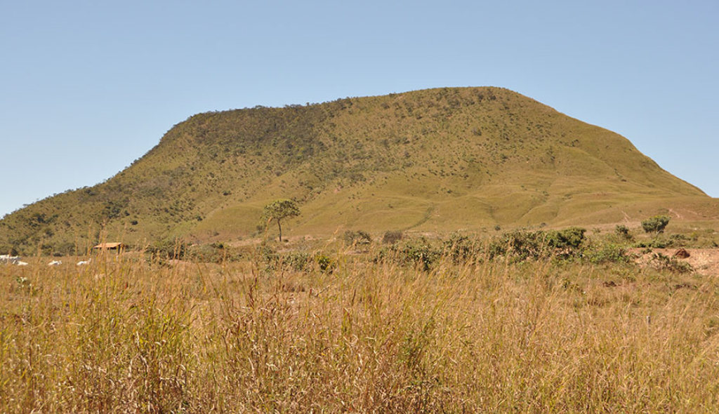 Visão afastada de encosta com vegetação verde em toda a sua extensão