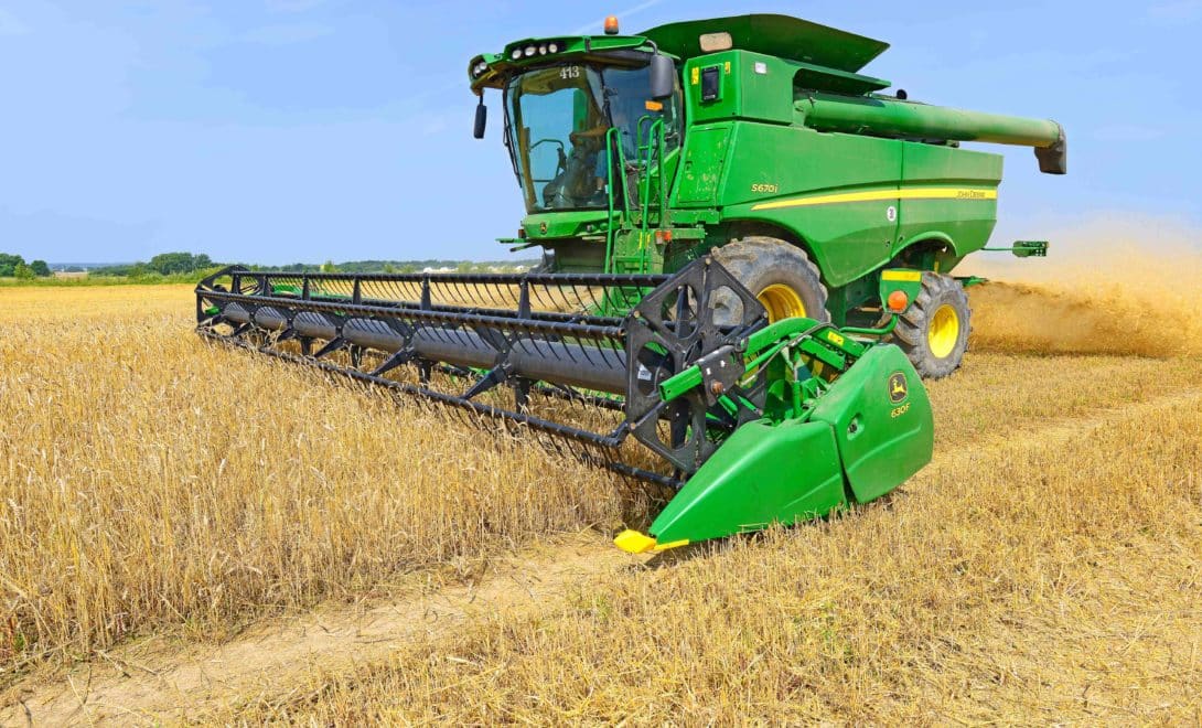 Colhedora em campo de trigo em operação