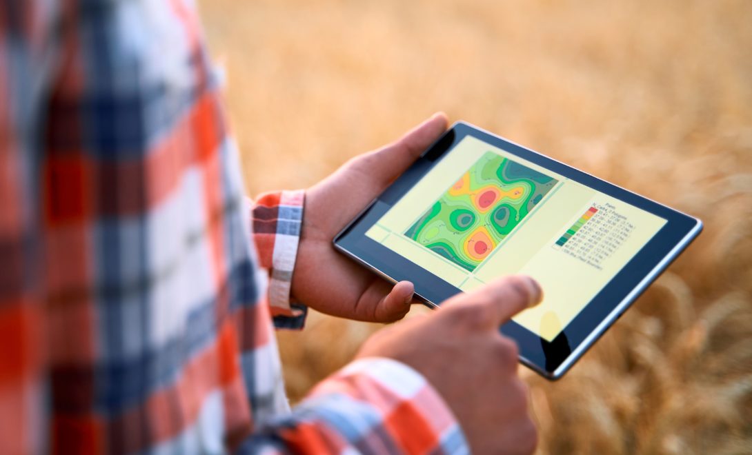 Homem segurando tablet com mapa representando a variabilidade de um talhão