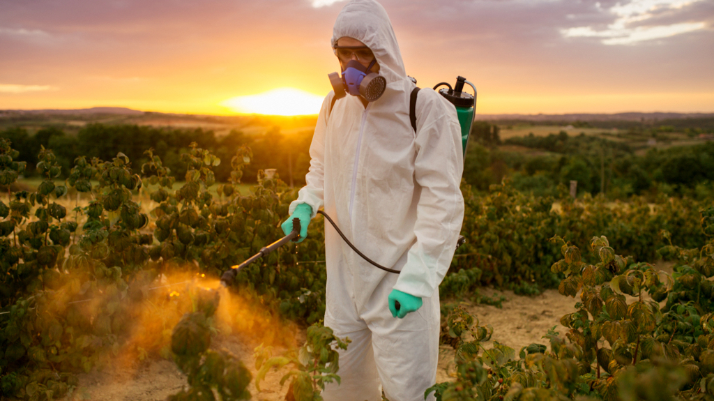 Homem aplicando defensivo agrícola