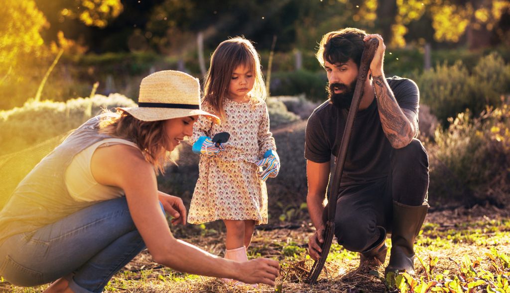 Foto de uma família de produtores rurais com uma mulher, um homem e uma criança