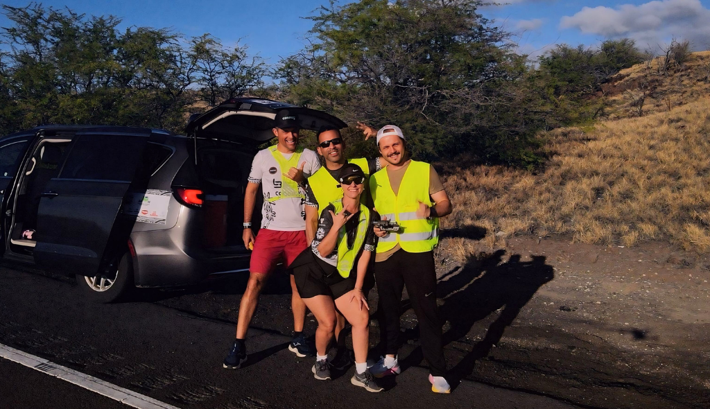 Equipe do atleta Alessandro Medeiros em frente - 3 homens e 1 mulher - à beira da estrada em Kona, Havaí.