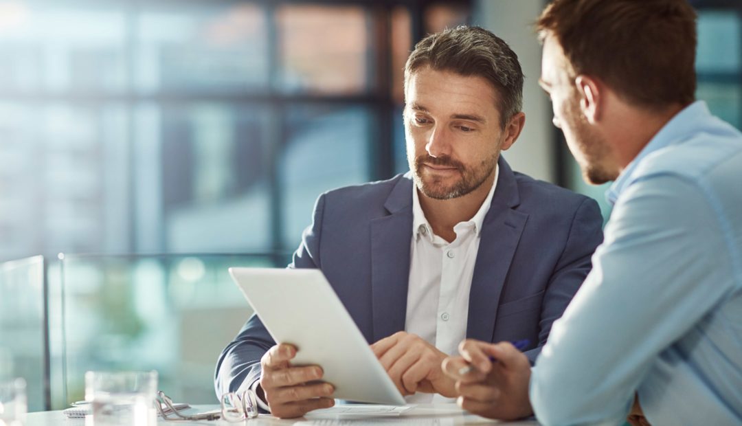 Dois executivos analisando dados em um tablet