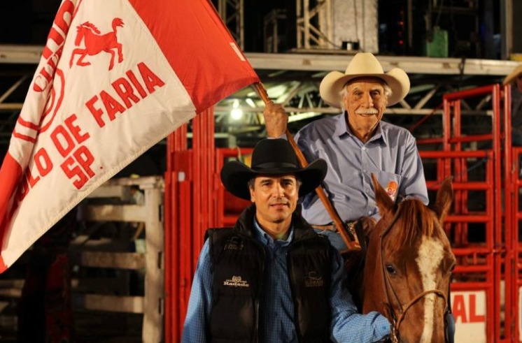 Tião Procópio ao lado do pai em uma arena de rodeio, representando suas raízes no rodeio e na vida no campo.